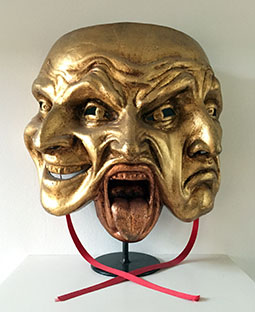 Afbeelding van een masker met drie gezichtsuitdrukkingen.